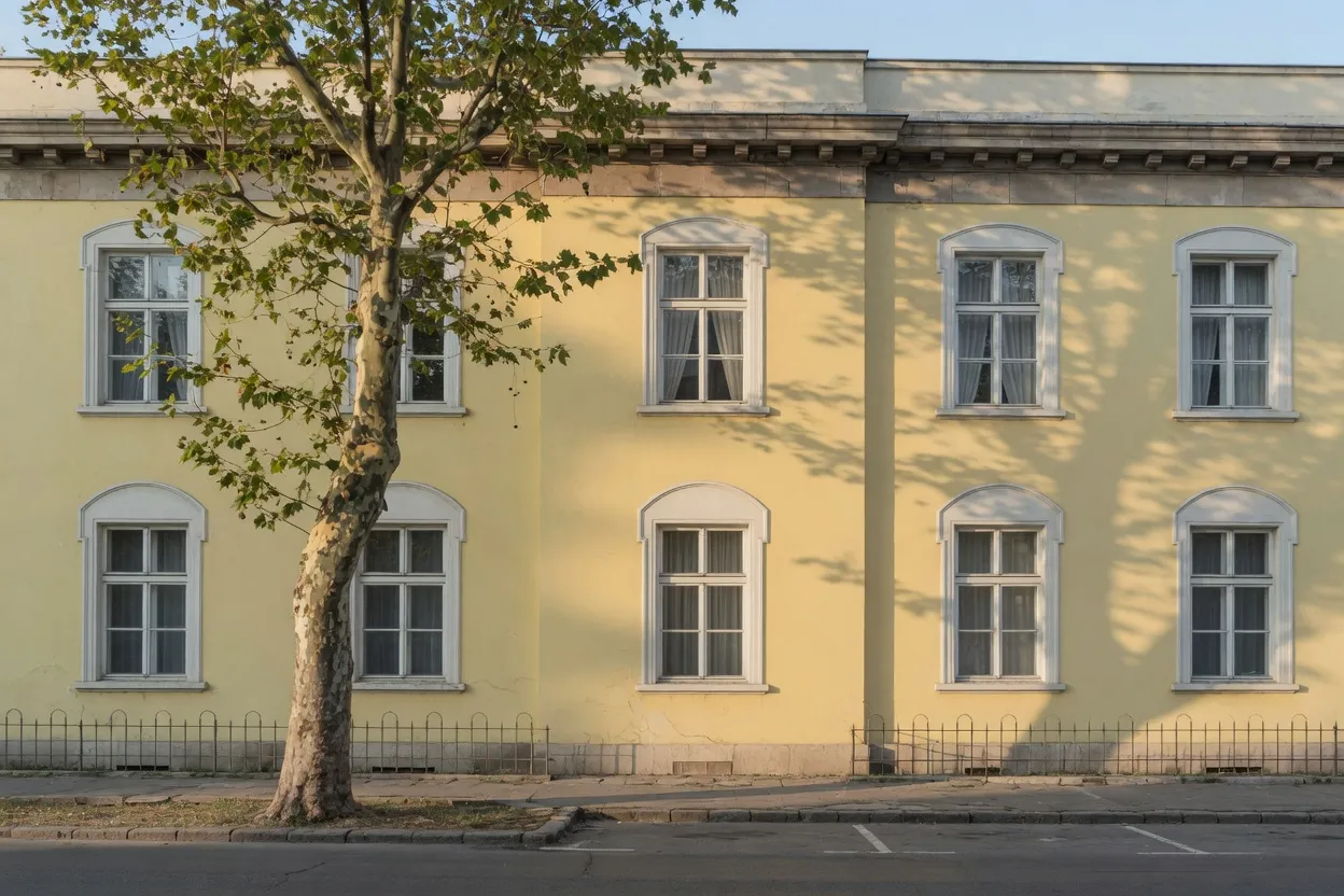 Yellow classical building facade with tall windows
